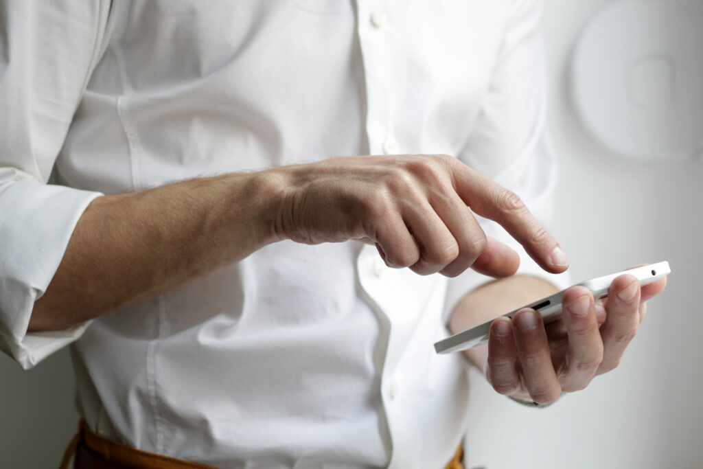 person holding white smartphone in white shirt